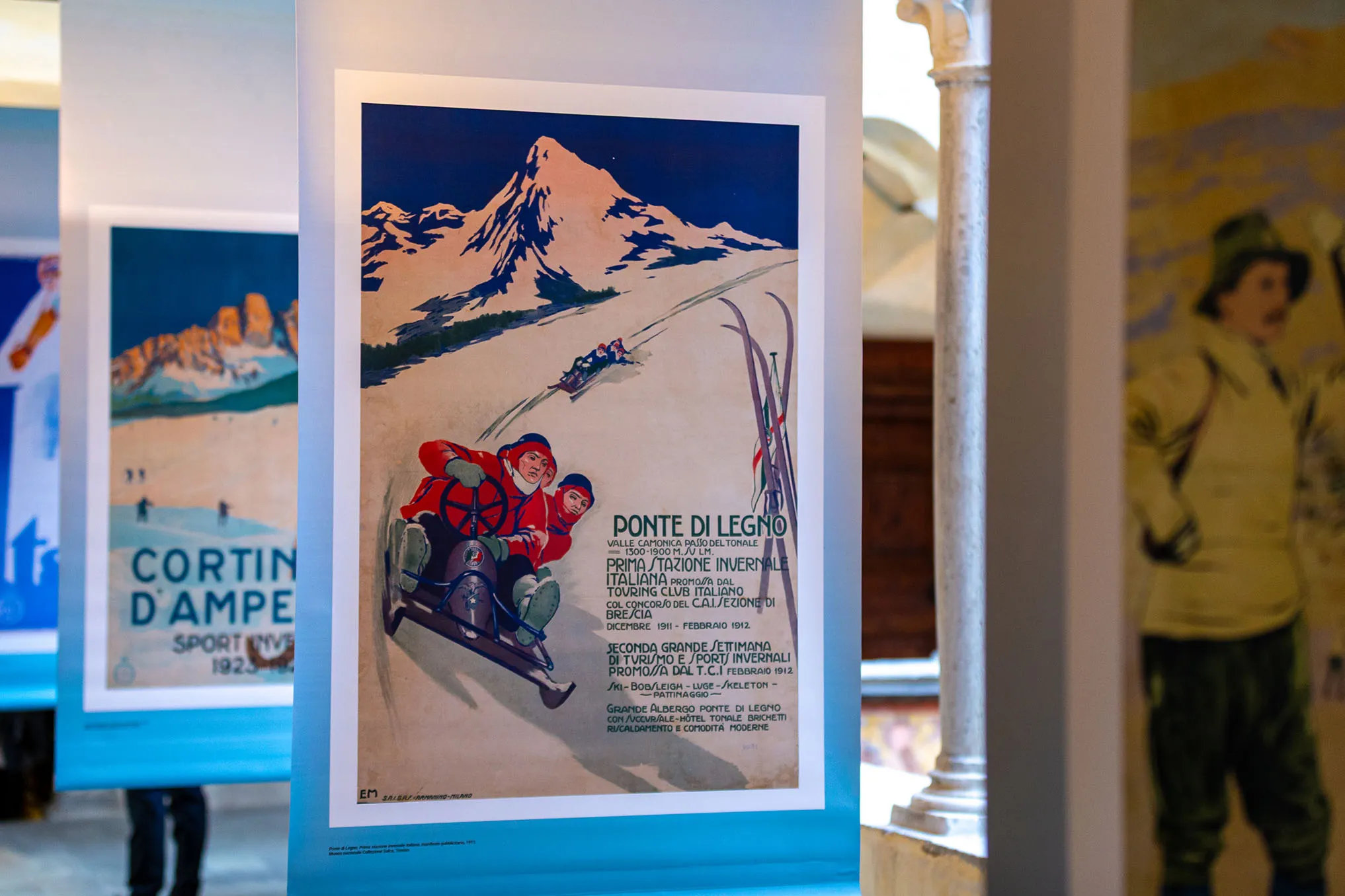 Due manifesti di promozione degli sport invernali dei primi del Novecento dedicati a Ponte di Legno e Cortina d’Ampezzo.